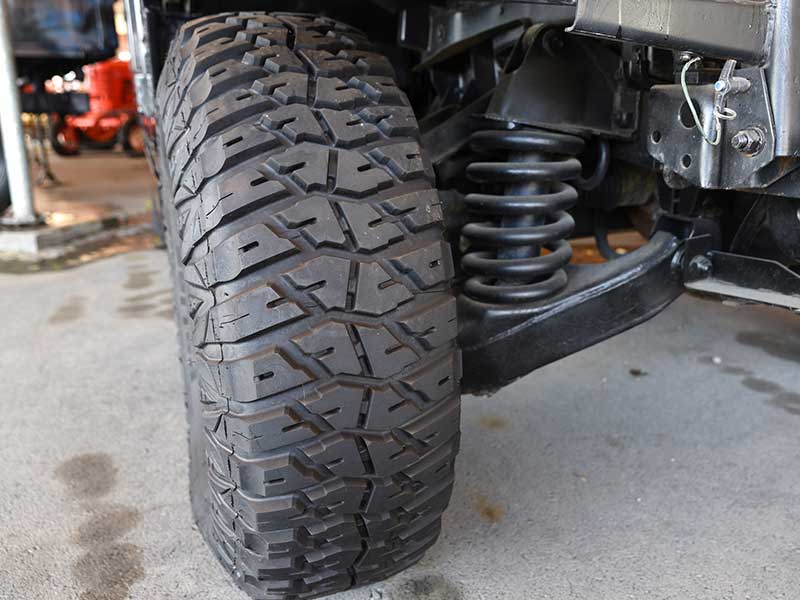 Close-up new military jeep tire and car suspension of an vintage jeep